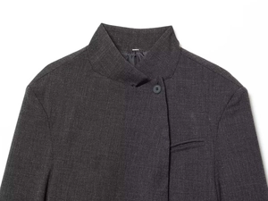 Detailed close-up of dark grey textured coat with stand collar and welt pocket detail