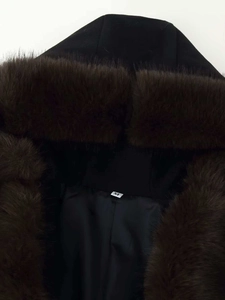 Detail of hood area featuring thick brown faux fur trim and black coat fabric texture