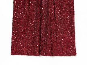 Close-up of high-density burgundy sequins on elegant evening dress fabric texture