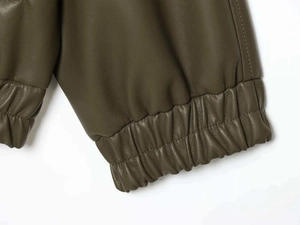 Dettaglio del polsino elastico e delle cuciture sulla giacca bomber in ecopelle verde