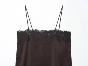 Close-up of black silk camisole with delicate eyelash lace trim and thin straps