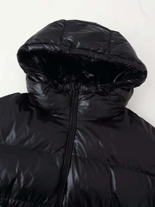 Detailansicht der schwarzen glänzenden Steppjacke mit Kapuze und Kordelzug-Elementen