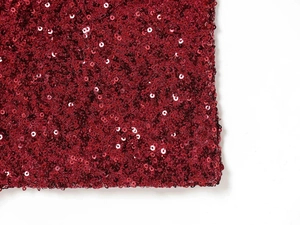 Close-up of sparkling burgundy sequins on high-quality fabric for elegant evening dresses