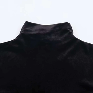 Dettaglio dell'elegante colletto alto in velluto nero con lucentezza e trama fine
