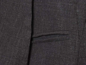 Macro view of dark grey blended fabric texture and precise stitching on the suit pocket