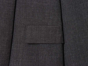 Detailed macro view of flap pocket on dark grey melange blazer with premium twill texture