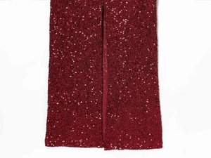 Detail view of burgundy sequins on the dress fabric with a stylish slit feature
