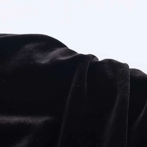 Detailed macro view of premium black velvet fabric showing soft texture and light reflection