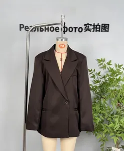 Macro detail of dark brown double-breasted blazer with structured shoulders and peak lapels