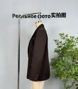 Detail view of deep coffee double-breasted blazer showing notched lapel and buttoned cuffs