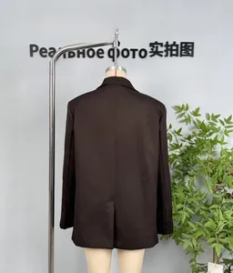Rear view of brown double-breasted blazer showing back vent and buttoned cuffs details