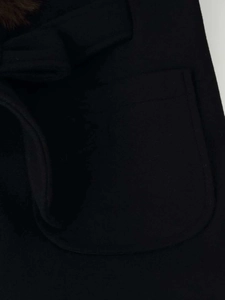 Close-up of a rounded patch pocket on a heavy wool coat with brown faux fur trim