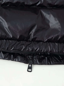 Makroaufnahme der glänzenden Steppstruktur und des schwarzen Reißverschlusses der Jacke