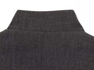 Close-up of the neckline and textured blend fabric of a charcoal grey blazer