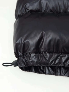 Detail der glänzenden Pufferjacke am Saum mit verstellbarem elastischem Kordelzug-Stopper