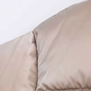 Detailed close-up of quilted champagne gold fabric with glossy windproof finish