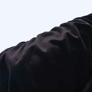 Detailed close-up of soft black velvet fabric texture with elegant drapes and soft sheen