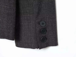 Macro shot of three black buttons on dark grey wool blend blazer sleeve cuff