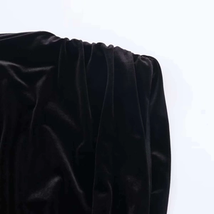 Detailed close-up showing high-quality black velvet fabric with glossy texture and soft drapes
