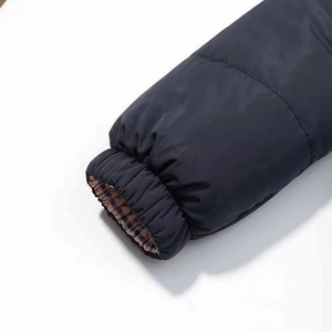Detail of windproof elastic cuffs and classic red plaid lining on a winter jacket