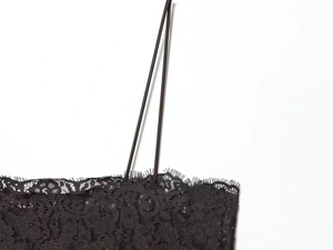 Detail view of the intricate black lace floral pattern and delicate eyelash trim on the top