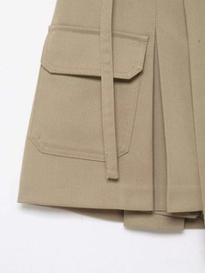 Vue détaillée du tissu en sergé kaki avec texture plissée et poche cargo sur le côté
