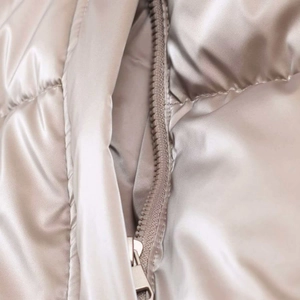 Detailed macro view of metallic satin fabric with silver zipper and quilted texture
