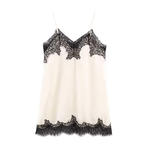 Detail of floral lace trim on cream satin camisole with delicate thin shoulder straps