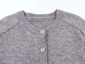 Detail of grey knitted cardigan showing ribbed round neck and button down closure