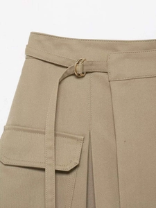 Détail de la jupe cargo kaki montrant le tissu sergé et la ceinture à boucle dorée en D