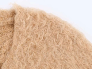 Close-up of beige plush knit fabric with soft mohair texture and fluffy wavy fibers