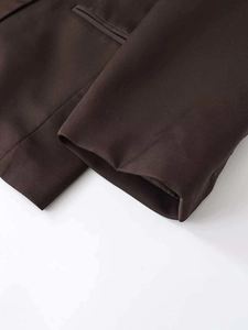 Detail shot of coffee brown oversized blazer showing twill fabric texture and pocket seams
