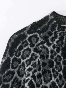 Close-up of leopard jacquard knit texture and shoulder seams on oversized sweater