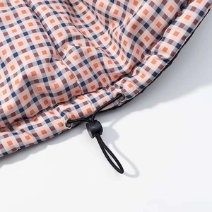 Detail of multi-color plaid puffer jacket hem with adjustable elastic drawstring toggle