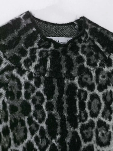 Close-up detail of leopard print knit sweater neckline with soft wool texture and brand label