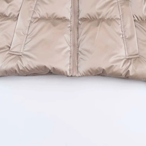 Detail of champagne gold metallic puffer jacket with zipper closure and flap pockets