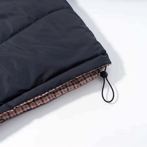 Detail of winter puffer coat hem featuring adjustable drawstring and brown plaid lining