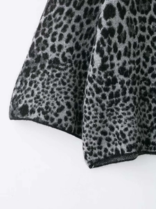Detailed close-up showing the knit texture and leopard pattern on the hem of this sweater