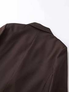 Detail view of the back collar and shoulder seams of a brown double-breasted blazer