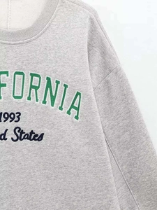 Detail of grey oversized sweatshirt showing rib collar and California 1993 embroidery