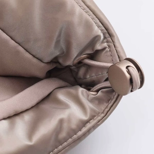 Macro shot of waterproof quilted fabric with drawstring lock on a padded taupe puffer jacket