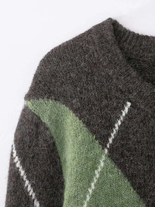 Close-up of crew neck knit sweater with diamond pattern and textured mohair finish