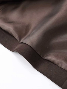 Detail of dark brown jacket lining and ribbed knit hem showing high-quality stitching