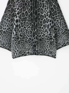 Detail shot of animal print leopard pattern on heavy knit sweater with soft fuzzy texture