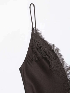 Detail of black silk satin dress featuring delicate eyelash lace trim and thin straps