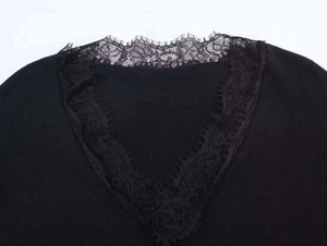 Detail of V-neckline with delicate eyelash lace trim on black knitted sweater
