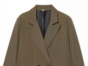 Detail eines olivgrünen Blazers mit zweireihigem Revers und schwarzem Satinfutter