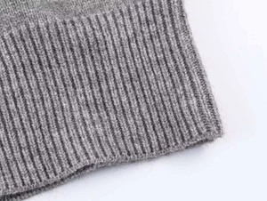 Close-up of grey ribbed knit texture showing soft wool blend fabric detail on cardigan