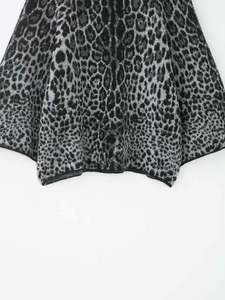 Macro shot of grey leopard print knit fabric showing the hem and heavy jacquard texture