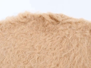 Close-up of beige faux shearling fabric texture for fashion knitwear and cozy apparel